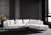 Sofá de canto elegante, branco, 310 x 265 cm | Estrutura em madeira de faia e aglomerado, tecido 100% poliéster | 7 almofadas, pernas de metal preto | Perfeito para espaços modernos